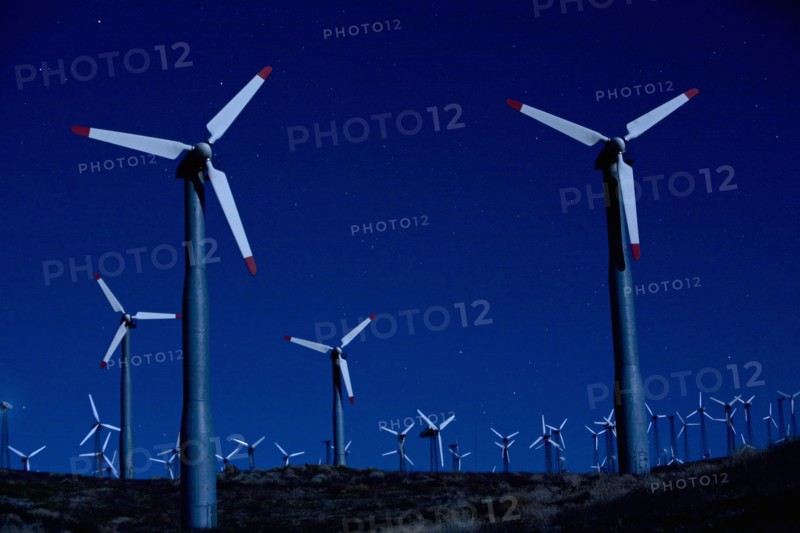 Wind turbines in landscape at night