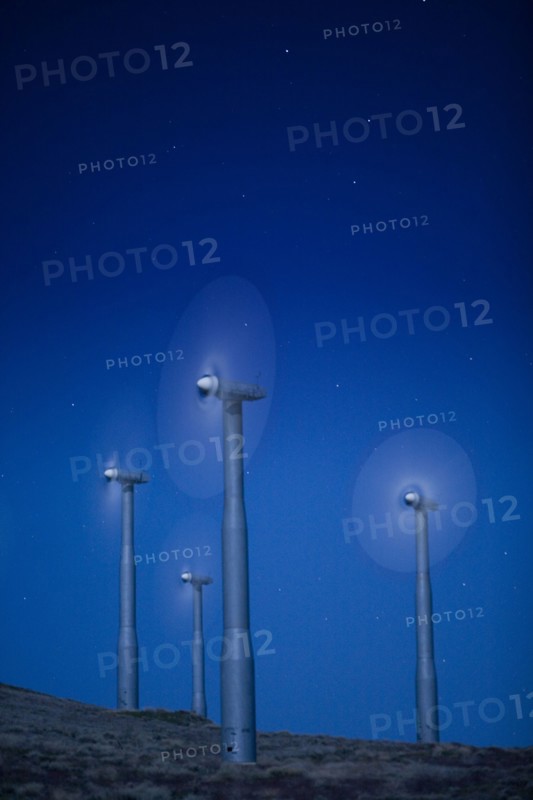 Wind turbines in landscape at night