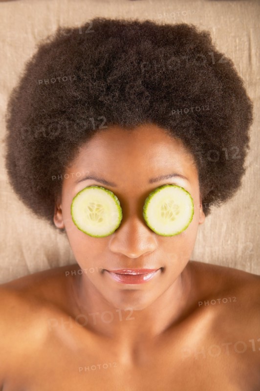 Woman with cucumber slices over eyes