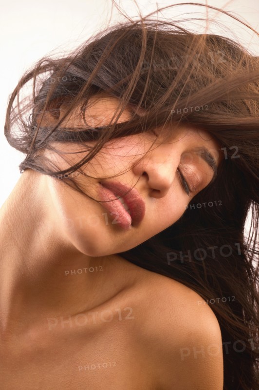 Studio shot of shirtless woman with long brown hair