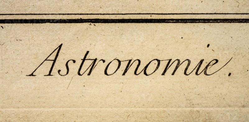 Word Astronomie written in antique script on old textured paper