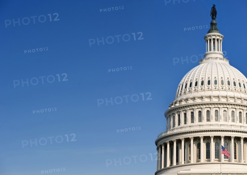 USA Capital building with flag against blue sky