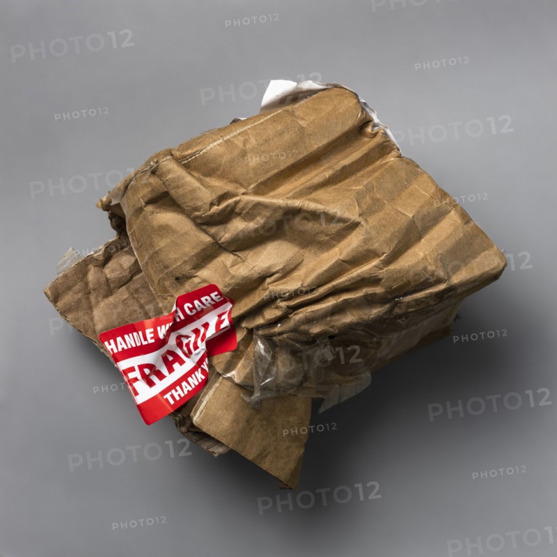 Fragile handle with care sticker on crushed package