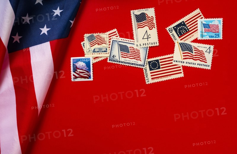 Retro postage stamps and American flag against red background