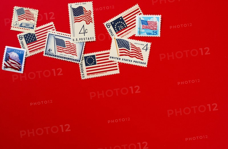Retro postage stamps and American flag against red background
