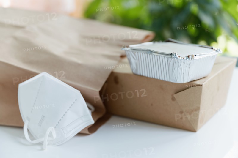 Take out food containers and face mask on table