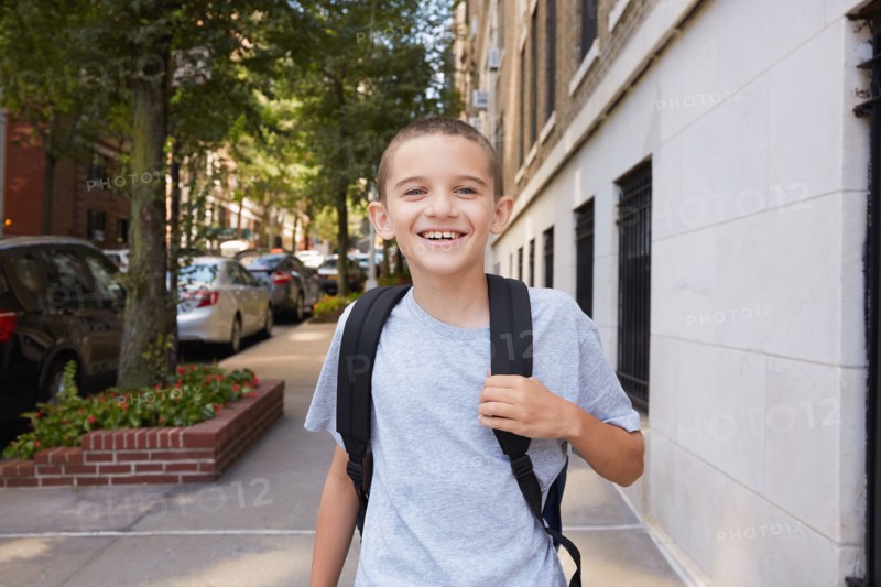 Portrait of smiling Boy wearing backpack in city