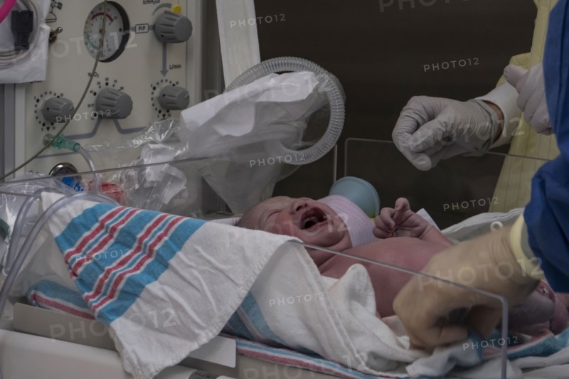 Doctors with crying newborn baby girl