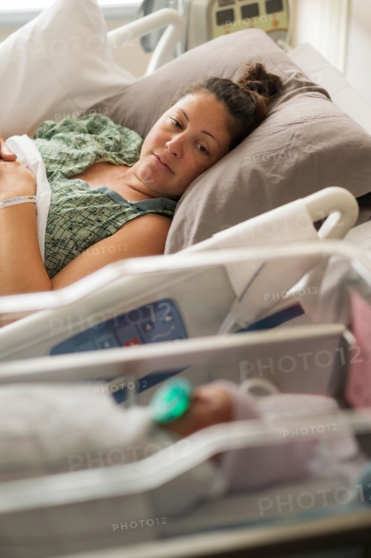 Mother lying with newborn baby girl