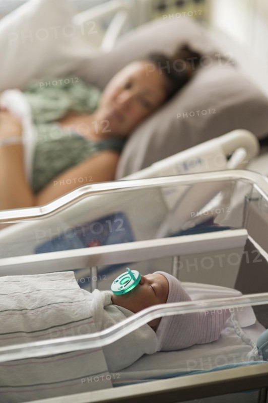 Mother lying with newborn baby girl