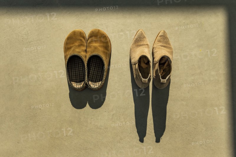 Two pairs of shoes lit by early morning sun