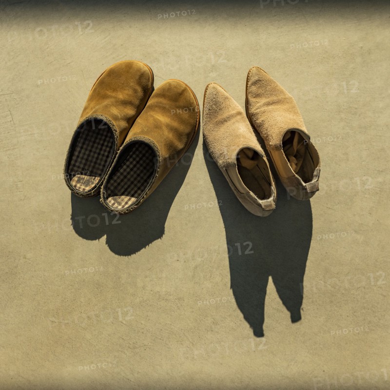 Two pairs of shoes lit by early morning sun