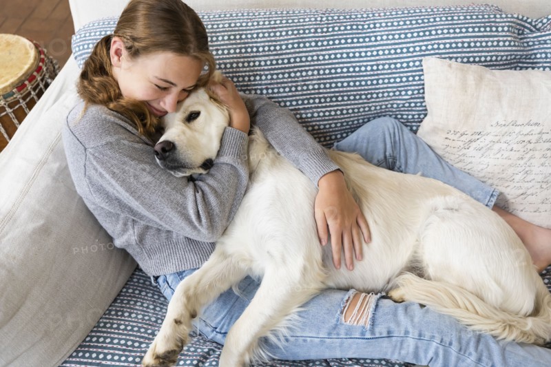 Girl embracing English Cream Golden Retriever