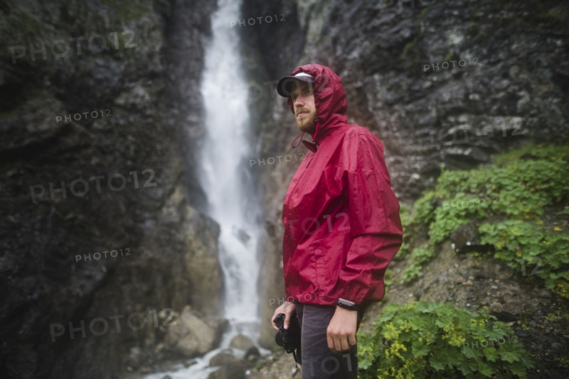 Hiker standing near waterfall
