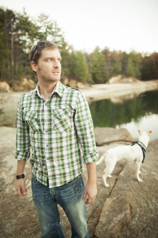Man and dog standing near lake