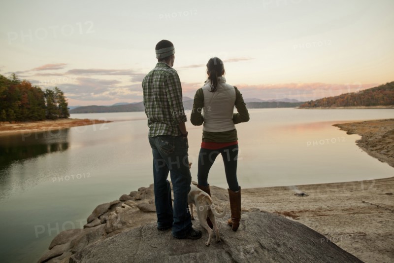 Couple and dog admiring remote lake