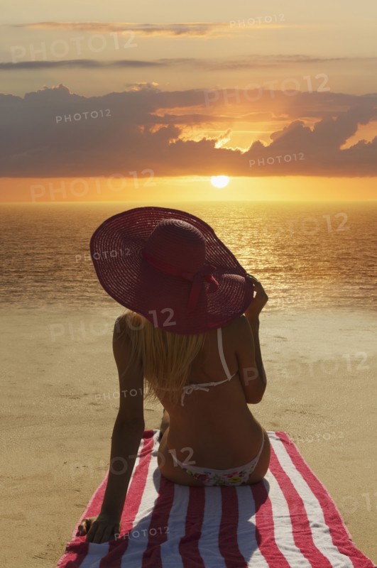 Caucasian woman admiring sunset on beach