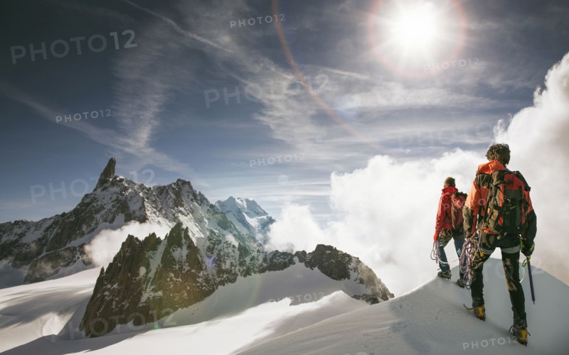 Caucasian hikers standing on snowy mountain top