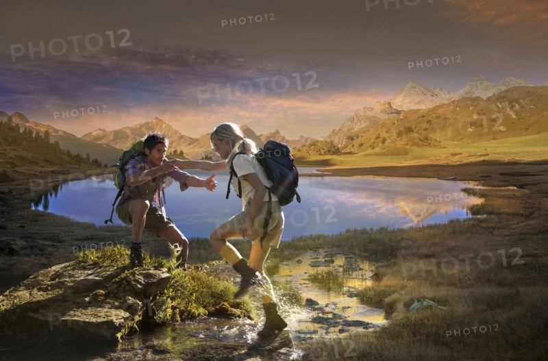 Caucasian hikers walking near remote lake