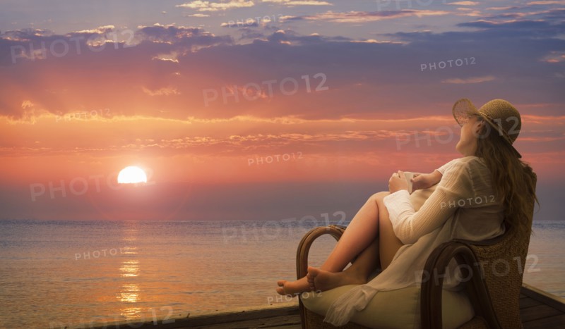 Caucasian woman admiring sunset on beach