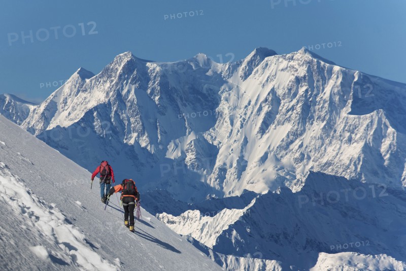 Caucasian hikers climbing snowy mountain