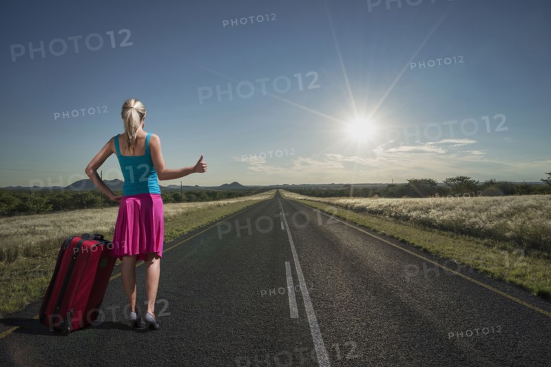 Caucasian woman hitchhiking on remote road