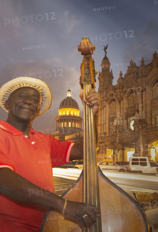 Hispanic musician playing upright bass in city