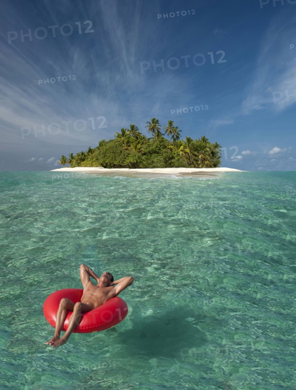 Caucasian man floating near tropical island