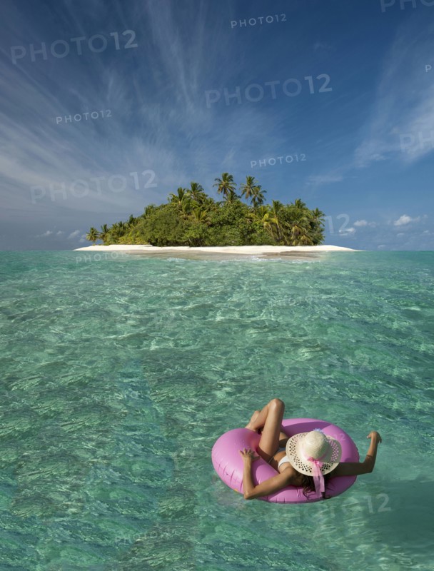 Caucasian woman floating near tropical island