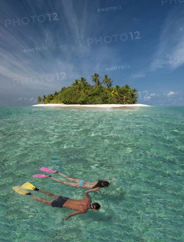 Caucasian couple snorkeling off tropical island