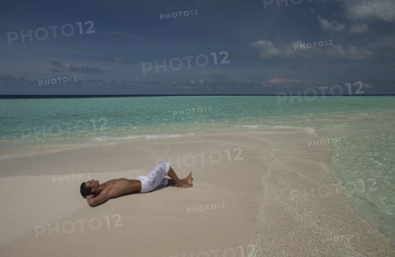 Caucasian man laying on beach