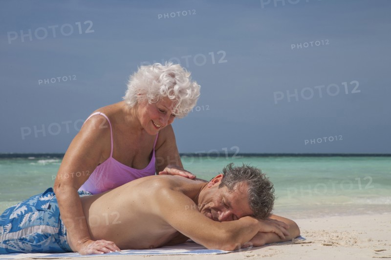 Older Caucasian couple relaxing on beach