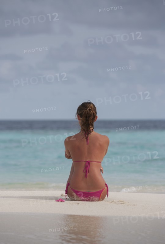 Caucasian woman sitting on beach