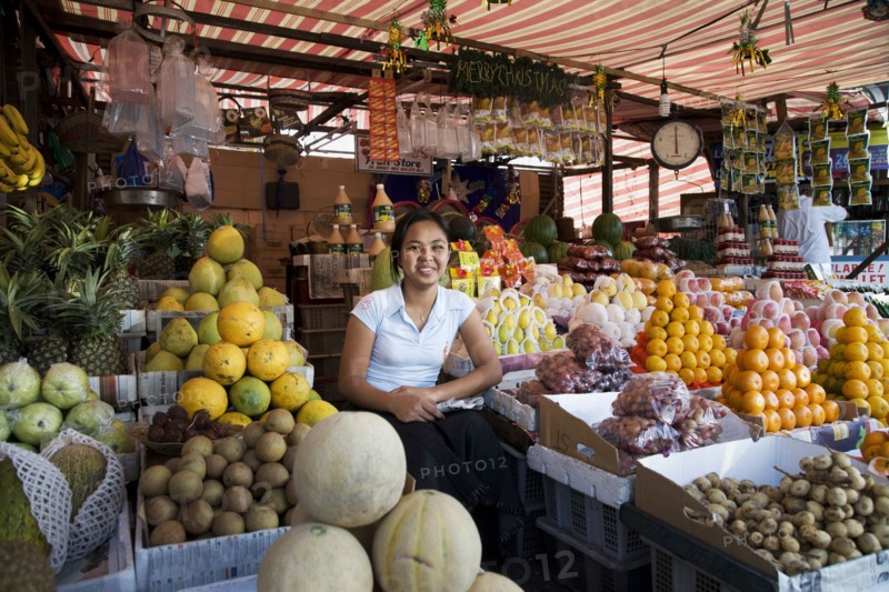 Asian vendor smiling at market