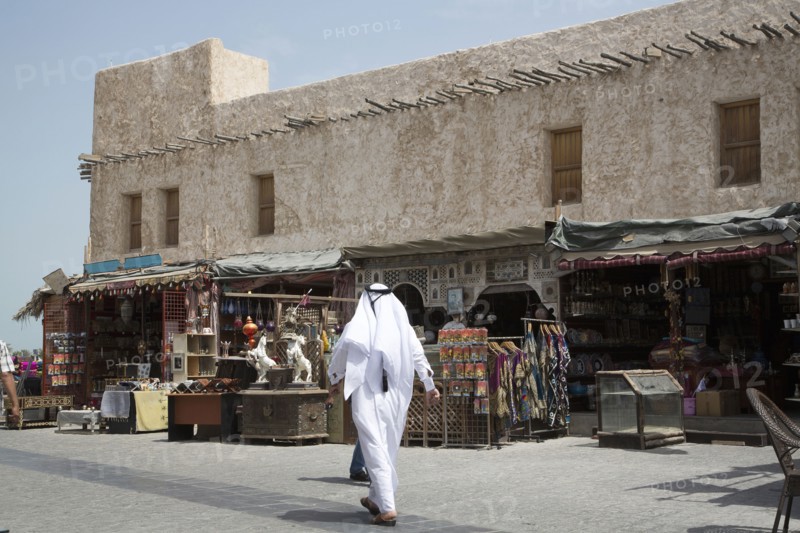Man walking outside market on Doha sidewalk