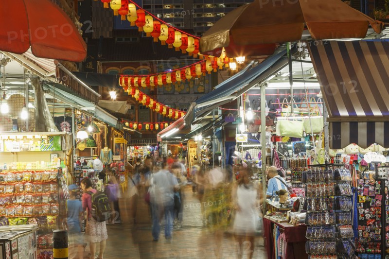 Blurred view of people shopping in outdoor market at night
