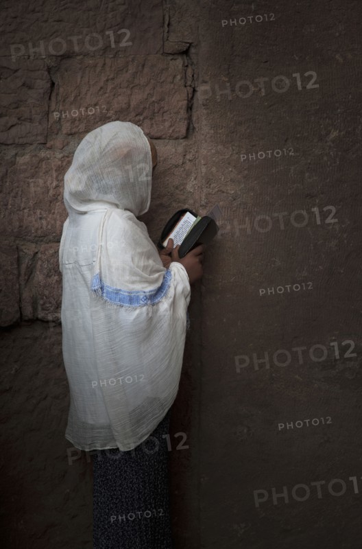 Black woman reading at wall