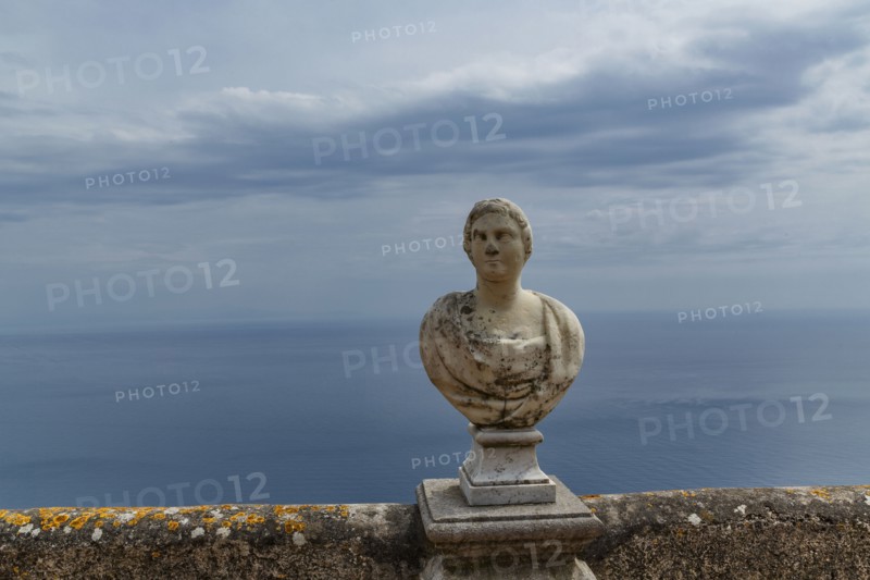 Carved bust on balcony over seascape