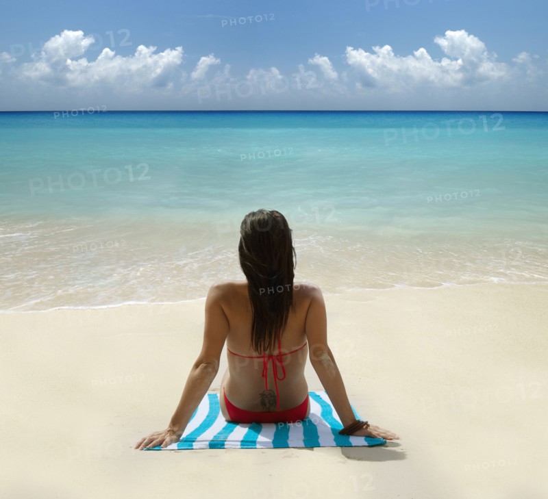 Caucasian woman laying on tropical beach