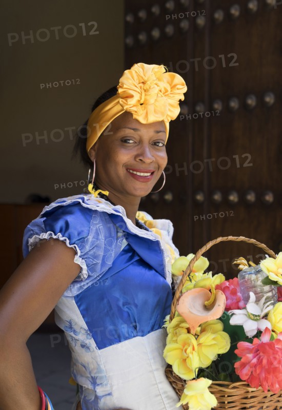 Hispanic woman carrying basket of flowers