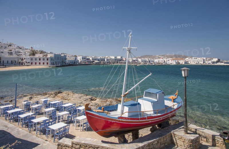 Boat and restaurant tables on oceanfront patio