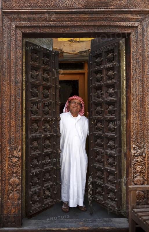 Smiling man opening ornate doors