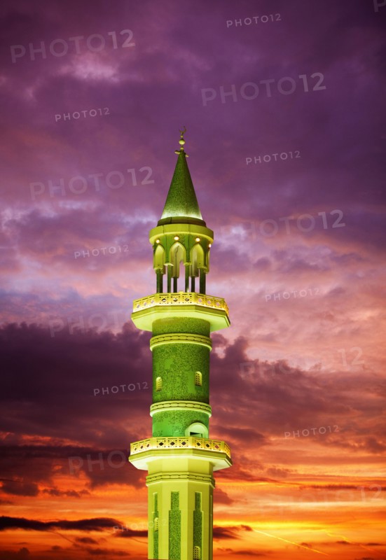 Illuminated tower against sunset sky
