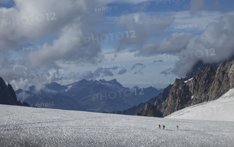 Hikers walking on glacier in remote landscape