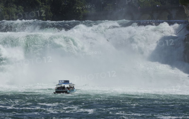 Boat floating near dramatic waterfall