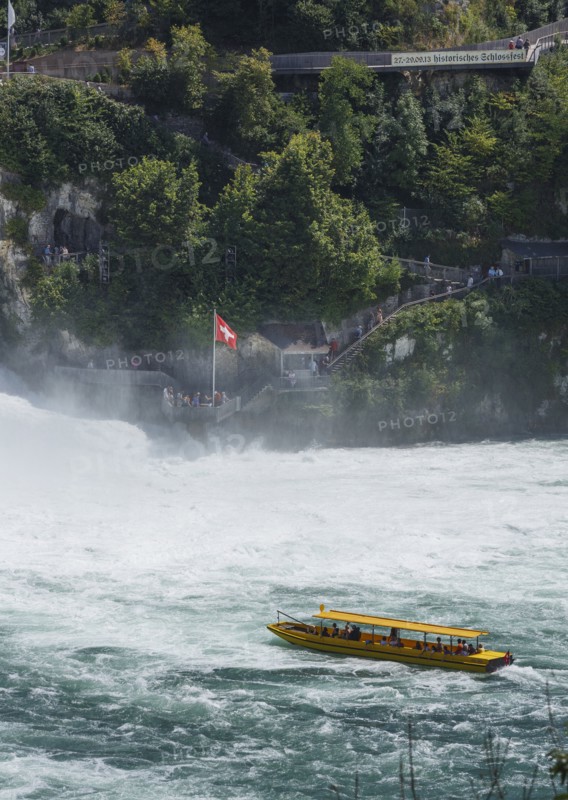 Boat floating near dramatic waterfall