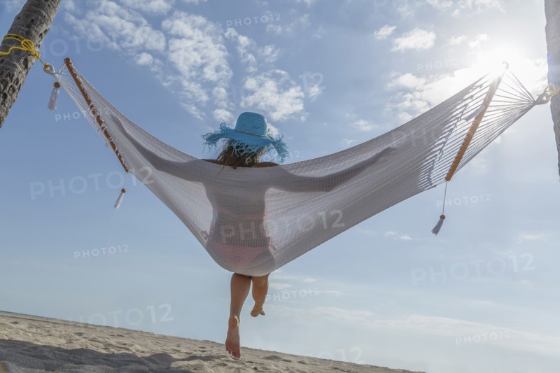 Caucasian woman in hammock at beach
