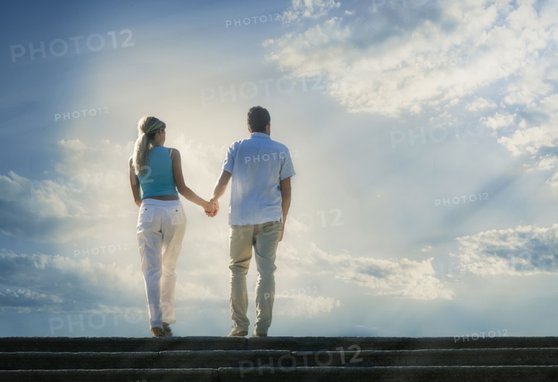 Caucasian couple admiring scenic view of clouds from staircase