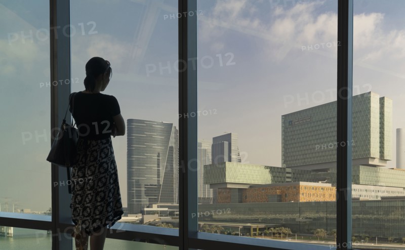 Caucasian woman admiring cityscape at window