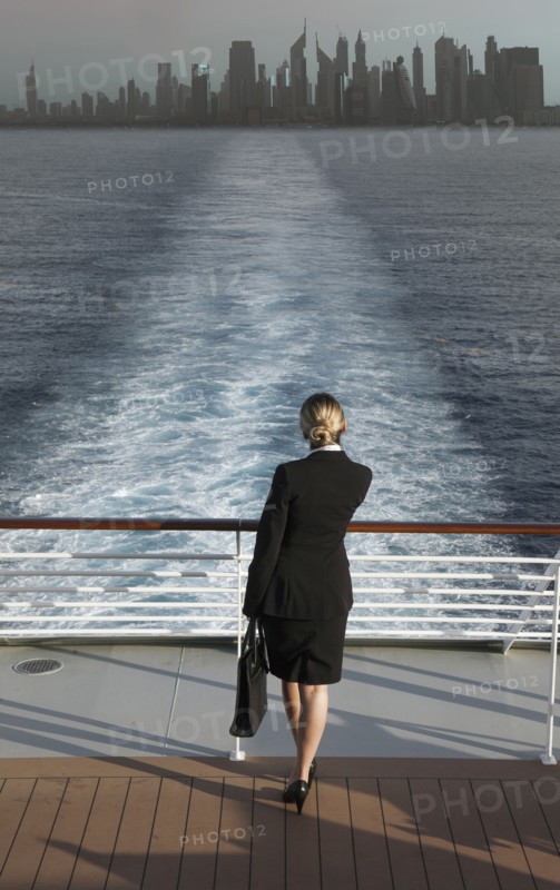 Caucasian businesswoman on boat leaving city